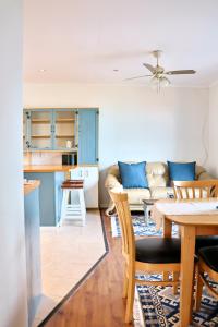 una cucina e un soggiorno con un tavolo e un divano di Apartment Sapphire a Herolds Bay
