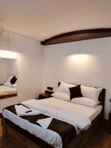 a bedroom with a large bed with white and black pillows at RKs HOME STAY in Shillong