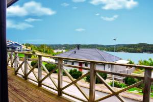 a view of a house on a wooden bridge at Fint hus med havsutsikt, stor terrass och med parkeringsplatser in Svanesund +7 photos