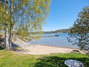 a beach with a dock in the water at Fint hus med havsutsikt, stor terrass och med parkeringsplatser in Svanesund