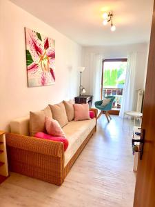 a living room with a couch and a painting on the wall at Privatzimmer Hanna in Dießen am Ammersee