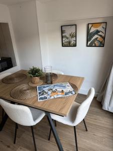 a dining room table with two white chairs and a table at Sabl'Appart Gare in Les Sables-d'Olonne