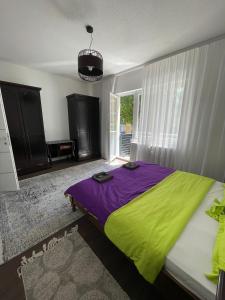 - une chambre dotée d'un lit avec une couverture verte et violette dans l'établissement Apartment IN Jajce, à Jajce