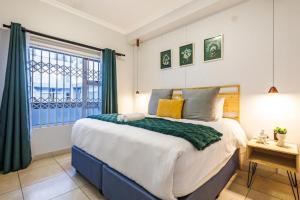 una camera da letto con un letto grande e una finestra di Exquisite Emerald Stay at Ridgeton Modern Two Bedroom Apartment in the Heart of Umhlanga Ridge Sleeps 6 a Durban Altre 53 foto