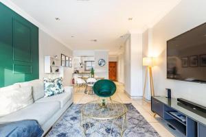 un soggiorno con un divano e un tavolo di Exquisite Emerald Stay at Ridgeton Modern Two Bedroom Apartment in the Heart of Umhlanga Ridge Sleeps 6 a Durban