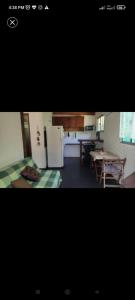 a kitchen with a table and a refrigerator at Surf homes in La Floresta