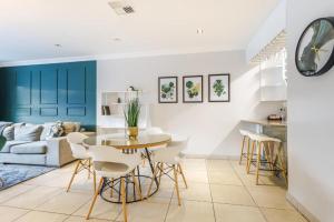un soggiorno con tavolo e sedie di Exquisite Emerald Stay at Ridgeton Modern Two Bedroom Apartment in the Heart of Umhlanga Ridge Sleeps 6 a Durban