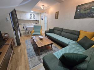 a living room with couches and a table and a kitchen at Jolly Apartment in Žabljak