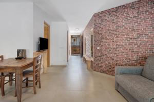 ein Wohnzimmer mit einer Ziegelwand, einem Tisch und einer Couch in der Unterkunft Villa Fontane in Truden