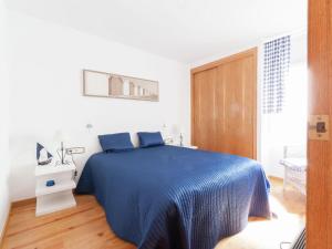 レスカラにあるBelvilla by OYO Albatros 6の白い部屋に青いベッドが備わるベッドルーム1室