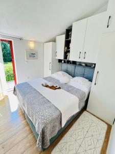 a bedroom with a large bed with white cabinets at Modern Apartment in Primošten in Primošten