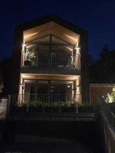 ボイニツェにあるR&J apartmányの夜間のバルコニー付きライトアップビル