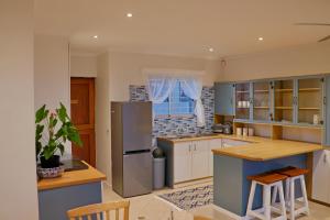 una cucina con armadi blu e frigorifero in acciaio inossidabile di Apartment Sapphire a Herolds Bay Altre 17 foto