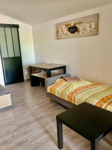 a hotel room with two beds and a desk at Studio climatisé et tout équipé in Saint-Didier