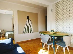 a dining room with a table and a painting on the wall at Sunny Balcony in Oliva