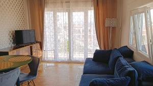 a living room with a blue couch and a large window at Sunny Balcony in Oliva