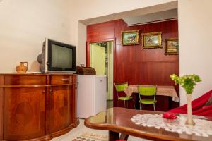 a living room with a television on a wooden dresser at Etno Gostilnica Villa Fulko in Ohrid