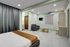 a hotel room with a bed and a chair at Hotel Well Suites Electronic City, Bengaluru in Bangalore
