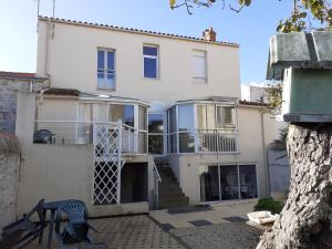 a white house with a deck and a balcony at Sabl'Appart Gare in Les Sables-d'Olonne