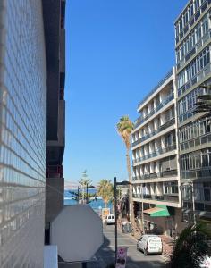 - une vue sur une rue bordée de palmiers et un bâtiment dans l'établissement Coral Canteras Playa - Frente al mar - Ideal parejas, familias o trabajo, à Las Palmas de Gran Canaria