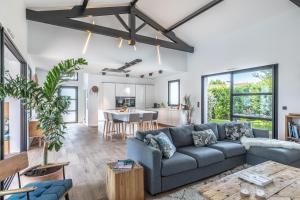 a living room with a couch and a table at Villa Manureva - Piscine au sel in Biarritz