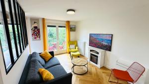 a living room with a blue couch and a fireplace at An Exceptional Apartment, 20 Min Paris, 10 Min Orly Airport, 30 Min Disney, 25 Min Versailles, Parking free in Antony