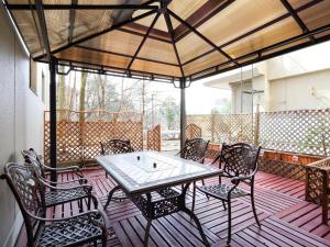 un patio con tavolo e sedie su un ponte di Kurobe Sun Valley Hotel - Vacation STAY 90890v a Ōmachi