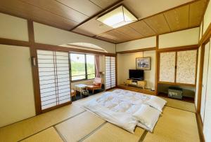 a bedroom with a large bed in a room with windows at Kurobe Sun Valley Hotel - Vacation STAY 90881v in Omachi