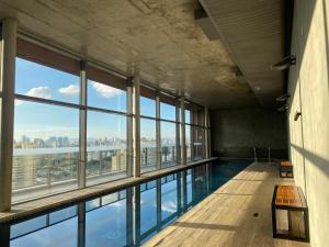 a swimming pool in a building with windows at Cristal Studio Brooklin aero CGH Berrini in Sao Paulo
