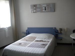 ニッサン・レ・アンサリューヌにあるL 'Acropoleのベッドルーム1室(ブルーヘッドボード付きのベッド1台付)