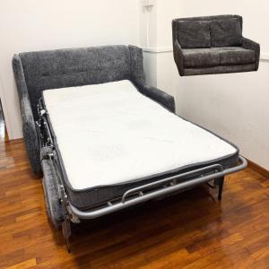 a bed sitting in a room next to a wall at Spacious Studio at citycentre in Singapore