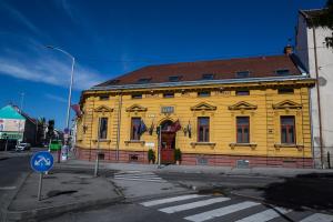a yellow building on the corner of a street at Boutique Hotel Sopianae in Pécs