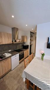 eine Küche mit einem Tisch und eine Küche mit einem Tisch und Stühlen in der Unterkunft La loge - EN PLEIN COEUR DU VILLAGE in Saint-Gervais-les-Bains