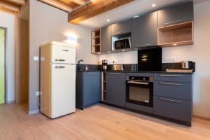 a kitchen with black and white appliances and wooden floors at 5 - Seigneurie Fouquet - Gaspareau in Le Palais +12 photos