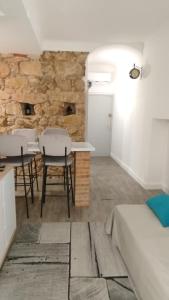 ein Raum mit einem Tisch und Stühlen und einer Steinmauer in der Unterkunft T2 type new yorkais in Ajaccio