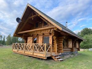 a log cabin with a gambrel roof at Domy z Bali nad jeziorem - Leśna Oaza in Międzyrzecz
