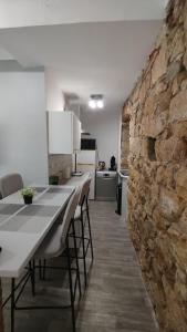 eine Küche mit einem Tisch und einer Steinmauer in der Unterkunft T2 type new yorkais in Ajaccio