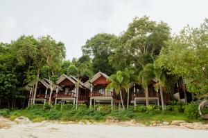 a row of houses on the beach with trees at Tubtim Resort in Ko Samed