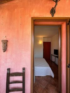 a room with a bedroom with a bed and a chair at da Bonny in Villasimius
