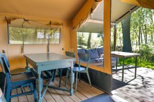 a table and chairs on a porch of a caravan at Camping de Heemtuin in Tripscompagnie