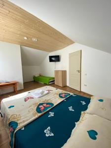 a bedroom with a bed with a blue comforter at Vila Rodica in Lunca Mare