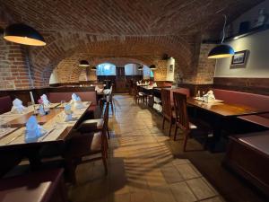 a restaurant with tables and chairs and a brick wall at Herberge in der Orangerie auf dem Schlossgut Altlandsberg in Altlandsberg