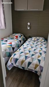 a bedroom with two beds in a room at Mobilhome Clim Toboggans aquatiques in La Teste-de-Buch