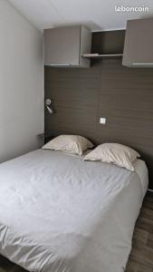 a large bed with two pillows in a bedroom at Mobilhome Clim Toboggans aquatiques in La Teste-de-Buch +5 photos
