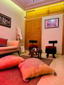 a living room with red pillows on a red rug at Riad Tislite & SPA in Marrakesh
