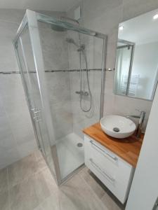 ein Badezimmer mit Glasdusche und Waschbecken in der Unterkunft Nid du Merle, Pessac in Pessac + 6 Fotos