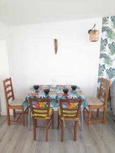 ein Esszimmer mit einem Tisch und vier Stühlen in der Unterkunft Nid du Merle, Pessac in Pessac