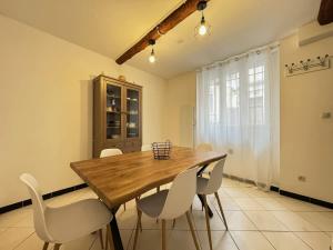 a dining room with a wooden table and white chairs at Chambre Orb 1 etage in Béziers