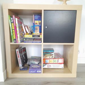 ein Bücherregal mit Fernseher und Büchern in der Unterkunft Nid du Merle, Pessac in Pessac