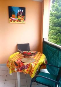 a table with a plate on top of a table at Appartement charmant à Sainte-Anne | 30 m² | Balcon et jardin in Sainte-Anne